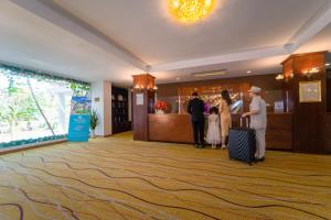 a group of people standing in a hotel lobby with luggage at Century Riverside Hue in Hue