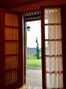 an open door to a porch with a view at Chalé Gran Reserva in Monte Verde