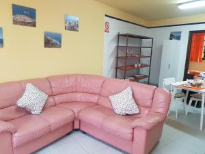 a pink couch in a living room with a table at Apartamento MiraMar in Garachico