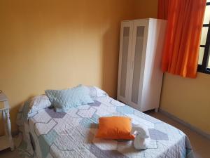 a bedroom with a bed with an orange pillow on it at Apartamento MiraMar in Garachico