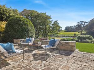 a patio with lounge chairs and a stone wall at Protestant Hall in Wildes Meadow