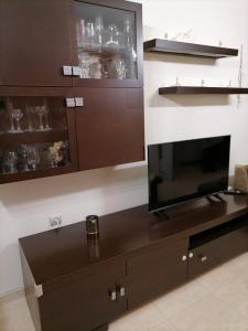 a living room with a flat screen tv on a cabinet at MARIALENAS HOUSE in Archangelos