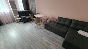 a living room with a couch and a table at Семейная Вилла Люстдорф in Odesa