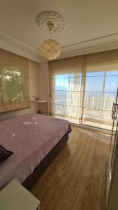 a bedroom with a large bed and a large window at Уютная вилла с шикарным панорамным видом in Alanya +33 photos