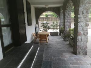 un patio con tavolo e sedie in un edificio di Appartamento Residence Castel Carlotta a Levico Terme