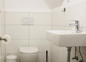 biała łazienka z umywalką i toaletą w obiekcie Fewo am Museum w mieście Schifferstadt