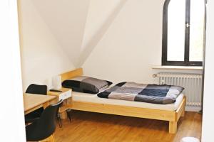 a bedroom with two beds and a desk and a desk at Fewo am Museum in Schifferstadt