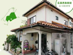 uma casa com duas bicicletas estacionadas fora dela em Hiroshima Saijo Youth Hostel em Higashihiroshima