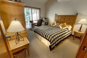 1 dormitorio con cama, escritorio y lámpara en Admira Properties - Whistler, en Whistler
