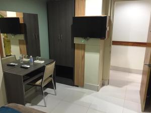 mały pokój ze stołem i telewizorem na ścianie w obiekcie RedDoorz Plus @ ABC Landmark Hotel w mieście Kidapawan