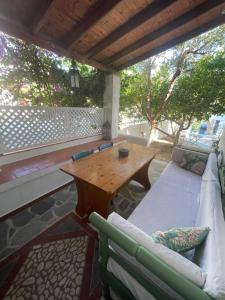 a patio with a wooden table and a couch at Patmos Villas in Grikos