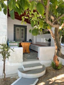 a porch with stairs and a tree in front of a house at Patmos Villas in Grikos