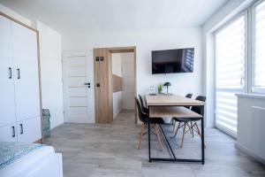 a kitchen and dining room with a table and chairs at Apartamenty Pawełek in Zator
