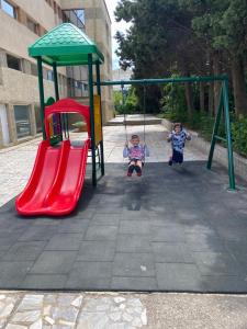 two children playing on a swing set in a playground at Kamenec Hotel in Nesebar