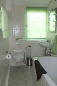 a bathroom with a tub and a sink and a toilet at Wohnen im Holzhaus in Niesky