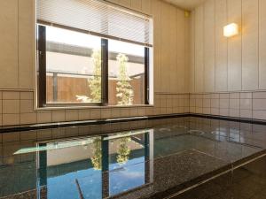 a room with a swimming pool and a window at Racine Home Harie in Takashima