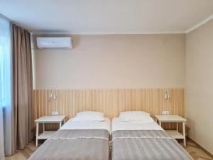 パヴロフスクにあるHotel Donのベッドルーム1室(ベッド2台、テーブル2台付)
