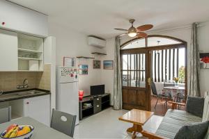 a kitchen and living room with a refrigerator and a table at Villa Amanda in Playa del Cura