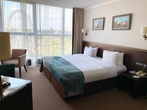 Un pat sau paturi într-o cameră la Riviera Hotel