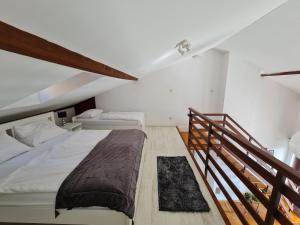 a bedroom with two beds and a staircase at Apartments Lounger Crikvenica in Crikvenica