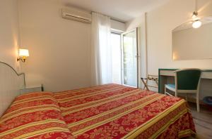 Schlafzimmer mit einem Bett, einem Tisch und einem Fenster in der Unterkunft Hotel San Marco in Lignano Sabbiadoro