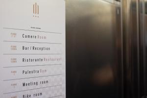a close up of a restaurant menu next to a refrigerator at Draconerium Hotel in Dronero