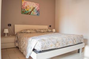 MontescudoにあるLa Valle Dei Caprioli Village Bungalow Park - Freelandia Azienda Agricolaのベッドルーム1室(ベッド1台付)が備わります。壁には絵画が飾られています。