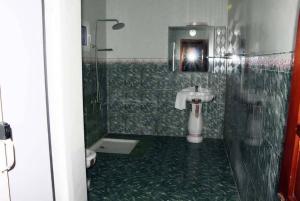 a bathroom with a shower with a sink and a toilet at Hotel Suites TALHAYA, NOUAKCHOTT in Nouakchott