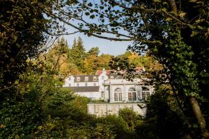 una gran casa blanca en medio de árboles en Barony Castle Hotel, en Peebles