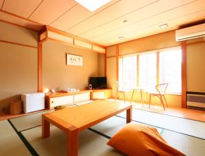 una sala de estar con una mesa de madera en una habitación en Ryosha Tsukiakari en Yamanakako