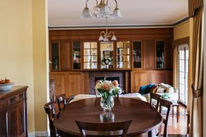 a dining room with a table with a vase of flowers at Lawson Lodge Country Estate in Macedon