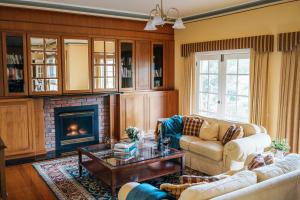 a living room with a couch and a fireplace at Lawson Lodge Country Estate in Macedon