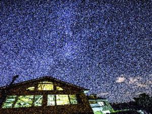 um céu estrelado acima de um edifício com uma janela em Pension Hoshi Ni Negaiwo em Furano