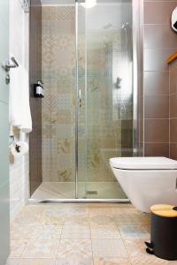 
a bathroom with a shower, toilet and sink at Hotel Okako San Sebastian in San Sebastián
