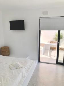 Habitación blanca con cama y espejo en AESIS en Krokos