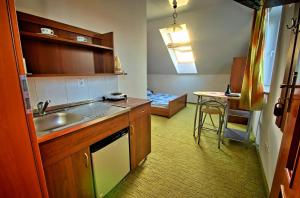 a kitchen with a sink and a table with a bed at Pokoje Gościnne Orka in Jarosławiec