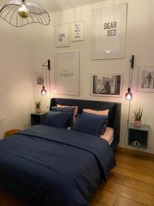 1 dormitorio con 1 cama con sábanas azules y cuadros en la pared en Cozy apt w/ king bed great for discovering Liege en Lieja
