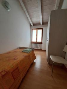 a bedroom with a bed and a chair and a window at Apartment Maria in Brenzone sul Garda