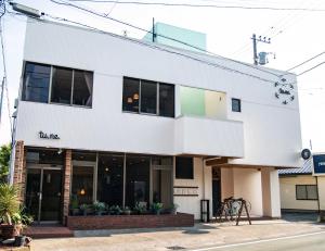 a white building with the name of a restaurant at tune Hostel（ツネホステル館山） in Tateyama