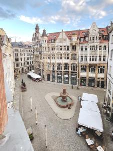 a large building with a fountain in the middle of a courtyard at Five Elements Hostel Leipzig in Leipzig