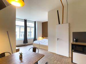 a room with a bed and a table and a room with a bed at Five Elements Hostel & Capsules Leipzig in Leipzig