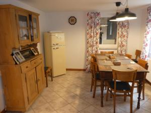 een keuken en eetkamer met een tafel en een koelkast bij s' Moose Hof in Weisweil