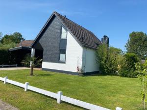 a black and white house with a green yard at Traumhaftes geräumiges Ferienhaus in Meernähe in Bruinisse +7 photos