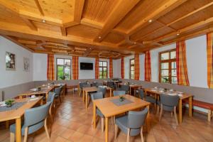 a restaurant with wooden ceilings and tables and chairs at Haus Weyregg - Pension in Weyregg