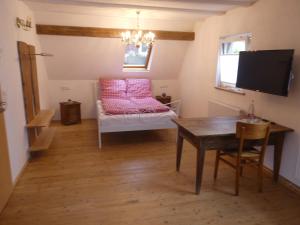 a room with a table and a bed with pink pillows at s' Moose Hof in Weisweil