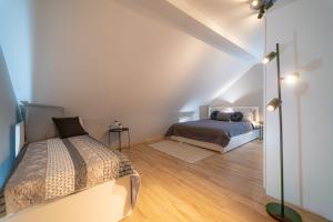 a attic bedroom with a bed and a mirror at Apartament Rodzinny PlusPlus Mountain Aparts in Świeradów-Zdrój