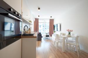 a kitchen and living room with a table and chairs at Apartament Dębowiec in Bielsko-Biala