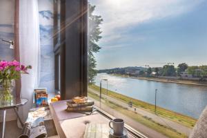a room with a window with a view of a river at Fragola Apartments Vistula View in Kraków