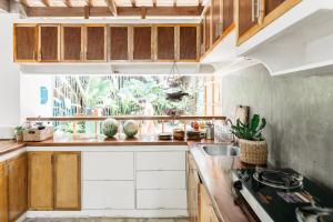 a kitchen with wooden cabinets and a sink at Higala Hostel Siargao in General Luna