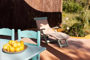 eine Schale Obst auf einem Tisch neben einem Stuhl in der Unterkunft Agroturismo Casa Morna Ibiza in Sant Carles de Peralta